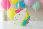 Neon bright unicorn birthday sugar cookie on a vibrant party background